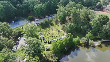 aerial orbit showing group of people doing sport exercise on grass field of park. sunny summer day near river in atlanta, usa