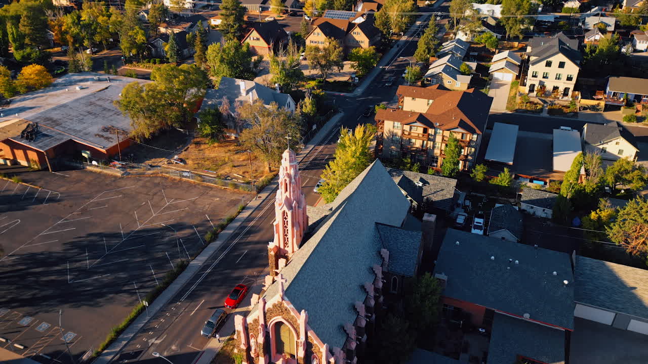 View on Nativity of Blessed Virgin Mary Chapel in Flagstaff, Arizona, USA. Drone footage rising above the green city on sunny day