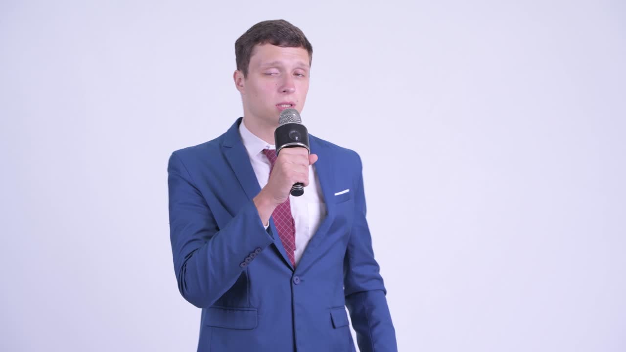 Young handsome businessman in suit with microphone