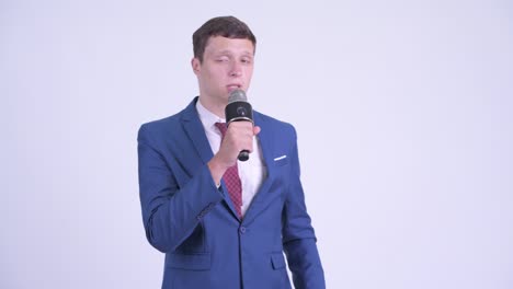 young handsome businessman in suit with microphone