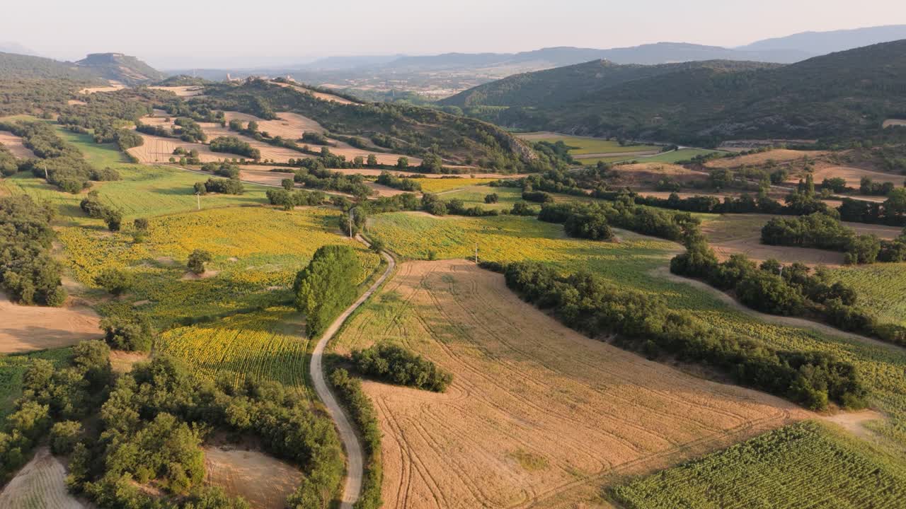 Approaching drone shot showing a scenic landscape of mountains and farmlands in Valderama, Spain.
