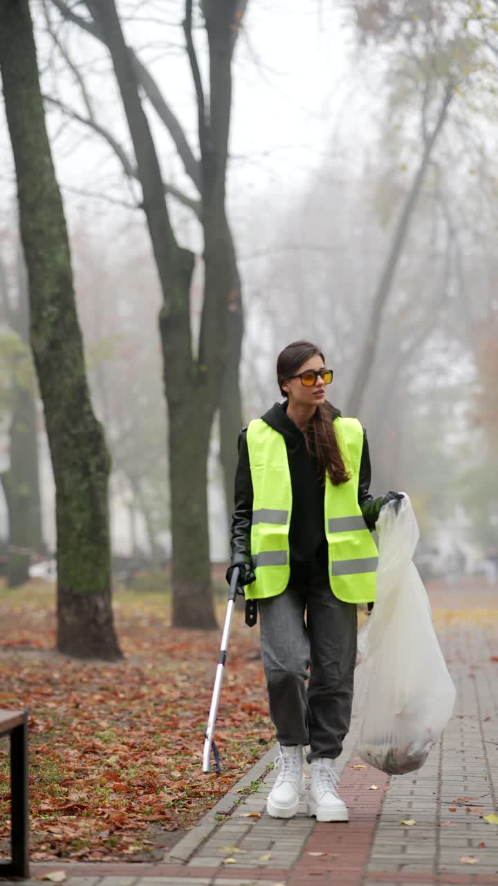 mujer limpiando la basura en un parque