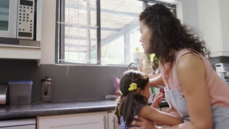 Girl-sitting-next-to-her-grandmother-washing-dishes-4K-4k