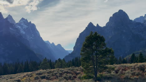 Jenny-String-Lake-Roadway-Malerische-Ausblicke-Grand-Tetons-National-Park-Mount-Moran-Peak-Sonnenstrahl-Atemberaubender-Herbst-Herbst-Perfektes-Wetter-Mitte-Spätnachmittag-Sonnenuntergang-Wolken-Filmischer-Schwenk-Nach-Links-Langsame-Bewegung