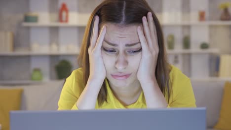 mujer de negocios enojada sentada en un escritorio trabajando desde casa en una computadora portátil sintiéndose frustrada.