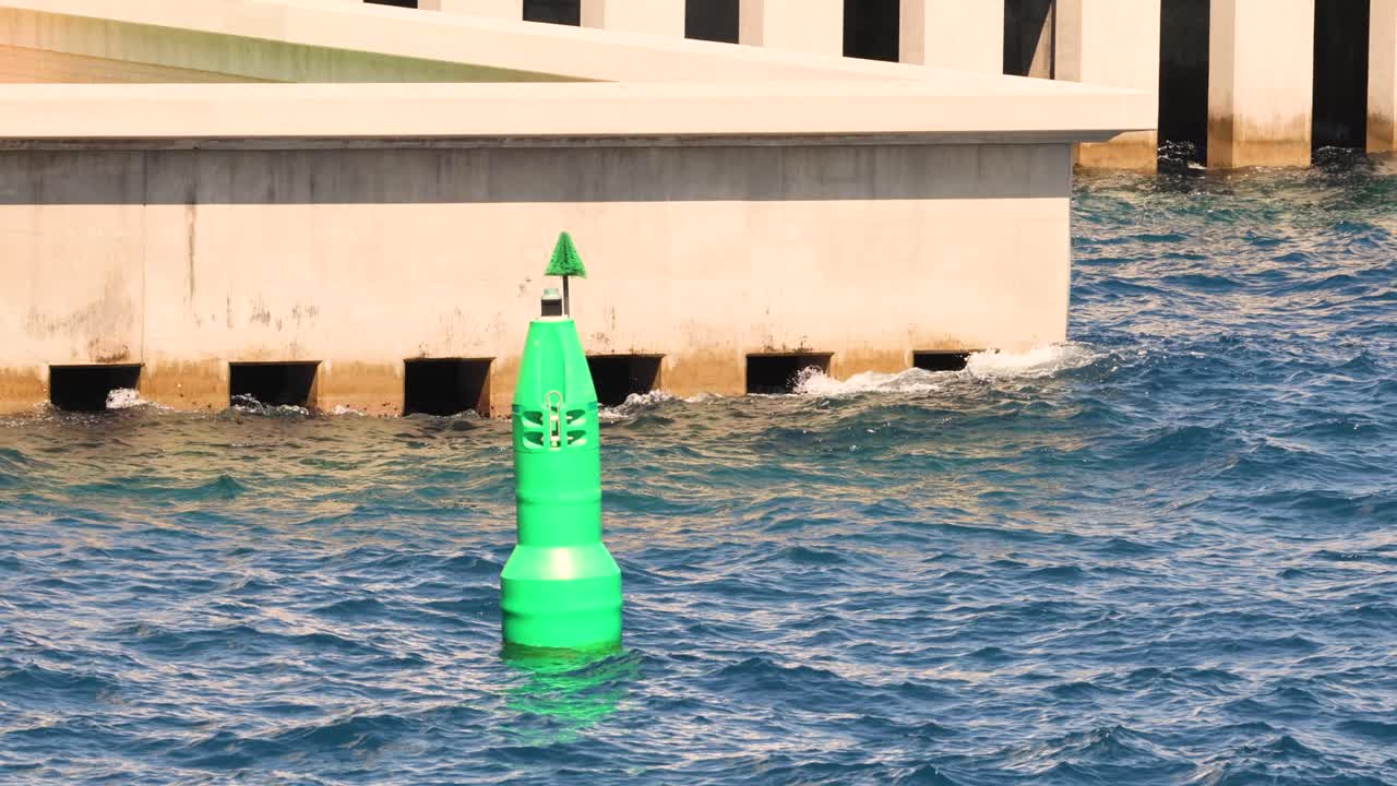 boya verde flotando cerca de una estructura de hormigón