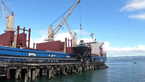 acercar la descarga del buque de carga en el lapso de tiempo de la fábrica de azúcar mientras las grúas trabajan para mover el envío