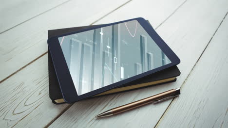 animation of a digital tablet lying on a notebook with graphs and statistics on the screen