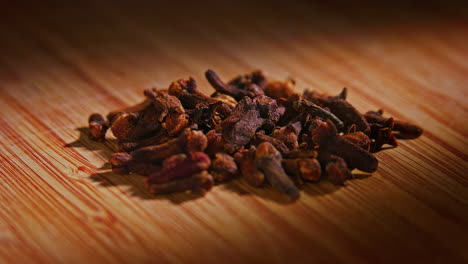 dried spice clove on a wooden surface with dramatic lighting, camera orbiting