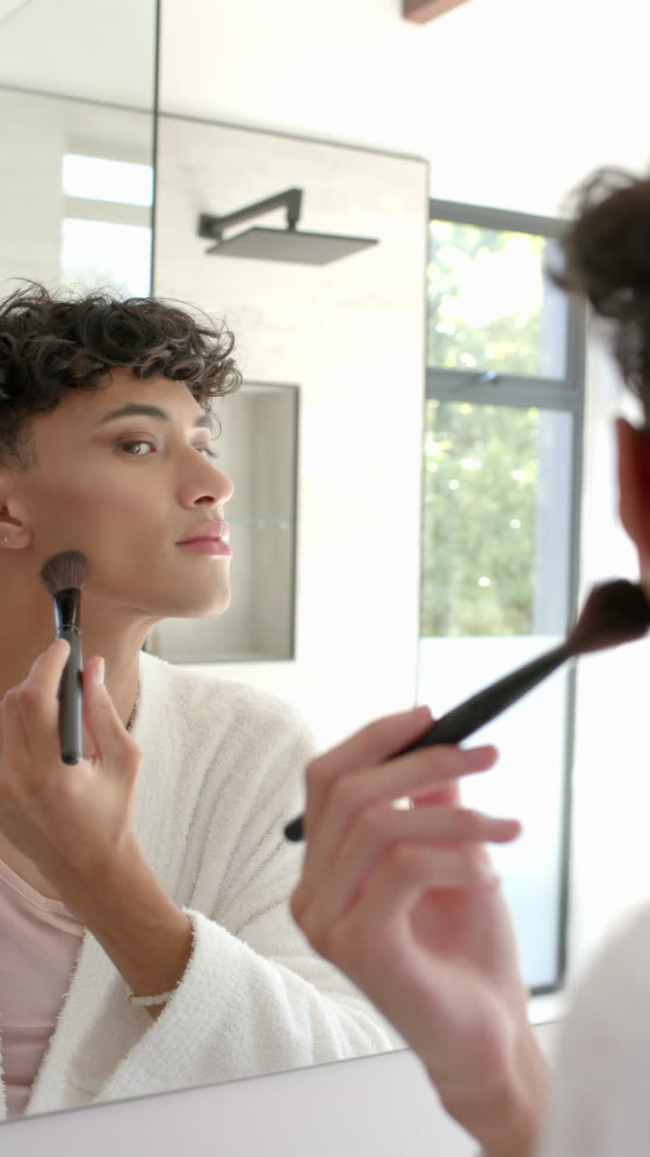 Vertical video: Person applying makeup at home, enhancing beauty with confidence in mirror