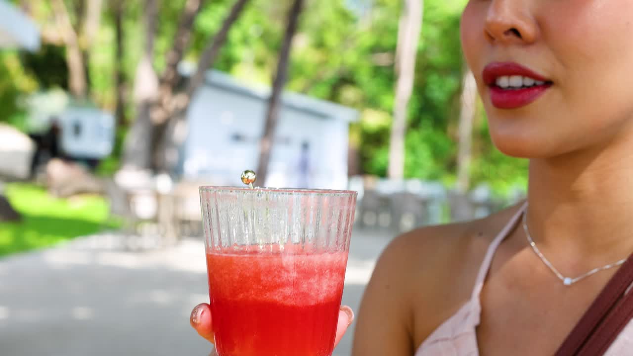 mujer saboreando refrescante jugo de sandía al aire libre