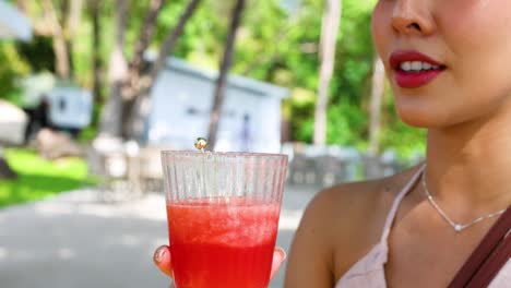 woman savoring refreshing watermelon juice outdoors