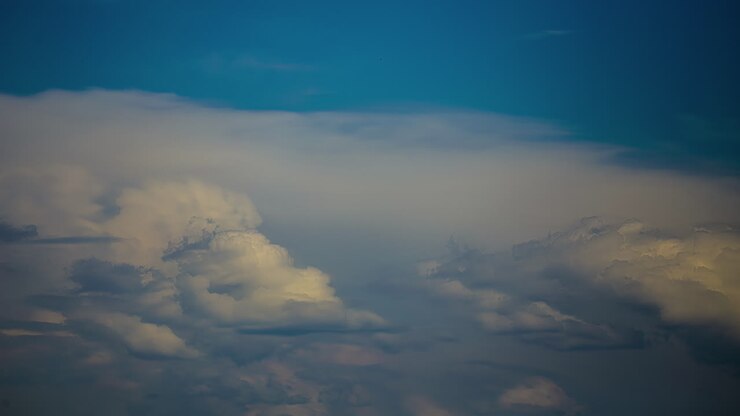 Timelapse of fluffy clouds rolling by a blue sky