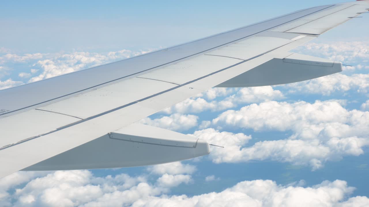 비행기의 창문에서 날개와 구름을 볼 수 있습니다.