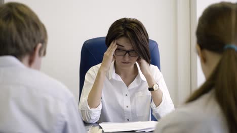 mujer estresada en una reunión de negocios
