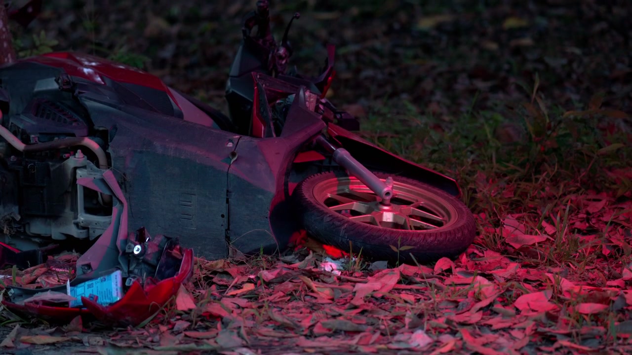 Motocicleta danificada caída no chão após acidente de trânsito