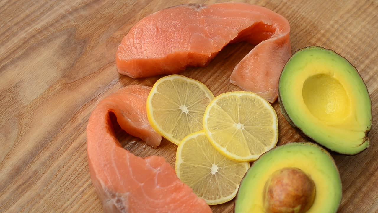 Salmone salato, avocado e limone su un tagliere da cucina. Gustosa natura morta, i prodotti combinati
