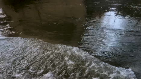 reflection in river water stream flowing under a bridge