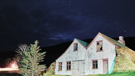 glowing stars at the evening sky over wooden turf houses in south iceland