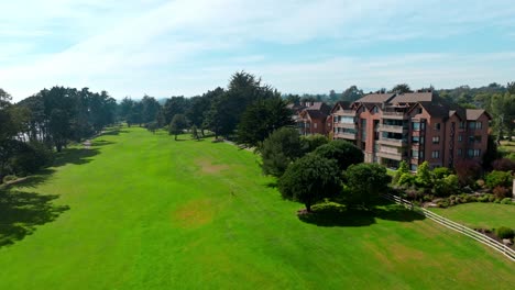edificios residenciales sobrevolados por drones junto al campo de hierba verde, bienes raíces exclusivos en chile