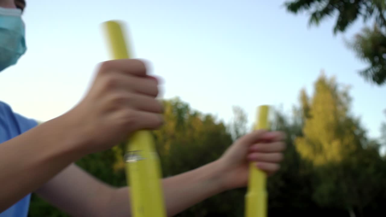 의료 마스크를 입은 십대 소년이 스포츠에 종사하고 있습니다.