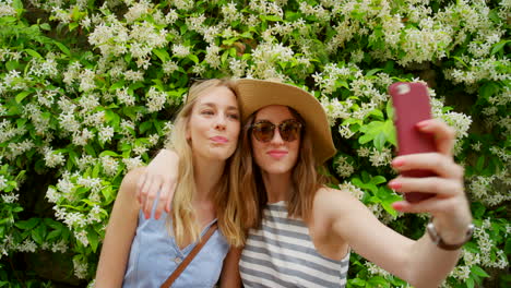 two friends taking a selfie in a flower garden