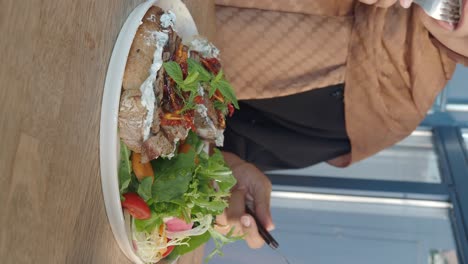 woman eating a sandwich and salad