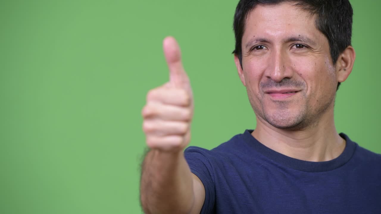 Close-up of happy Hispanic man giving thumbs up