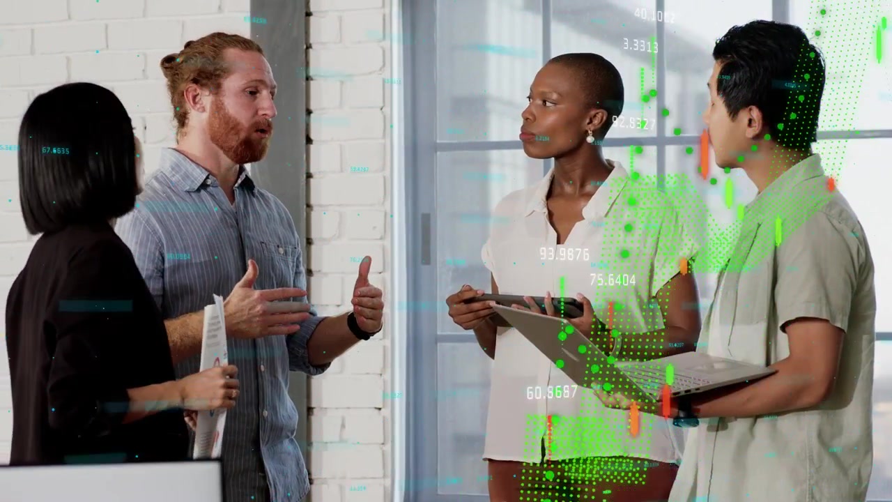 Business team debating, man-bun starting explanation, tablet laptop showing charts overlaying group