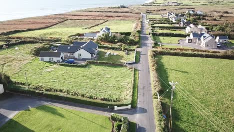 Vista-Aérea-De-Una-Pequeña-Casa-De-Campo-En-Connemara,-Irlanda,-Una-Carretera-Cruza-El-Pueblo