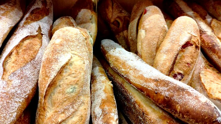 Bread, buns and other bakery products of golden color on store shelves in motion
