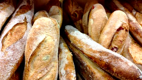 bread, buns and other bakery products of golden color on store shelves in motion