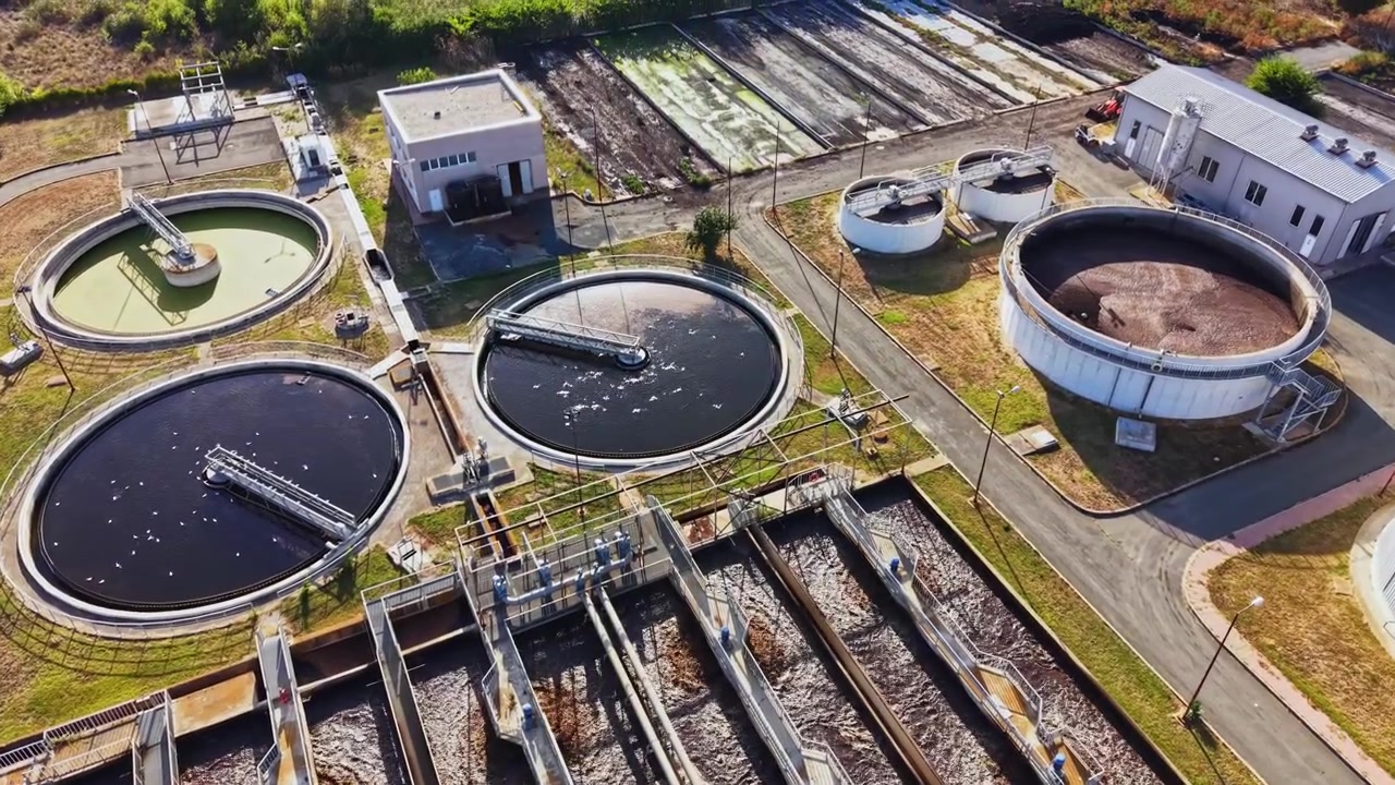 Water treatment facility with several tanks and filtration systems located in an industrial area during daytime