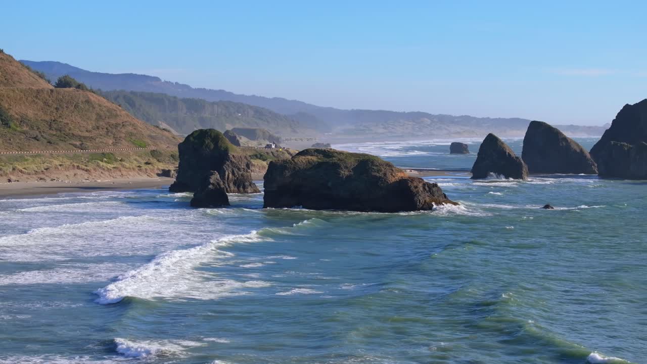 Scenic Oregon Coast with rocky shoreline and waves under clear blue sky