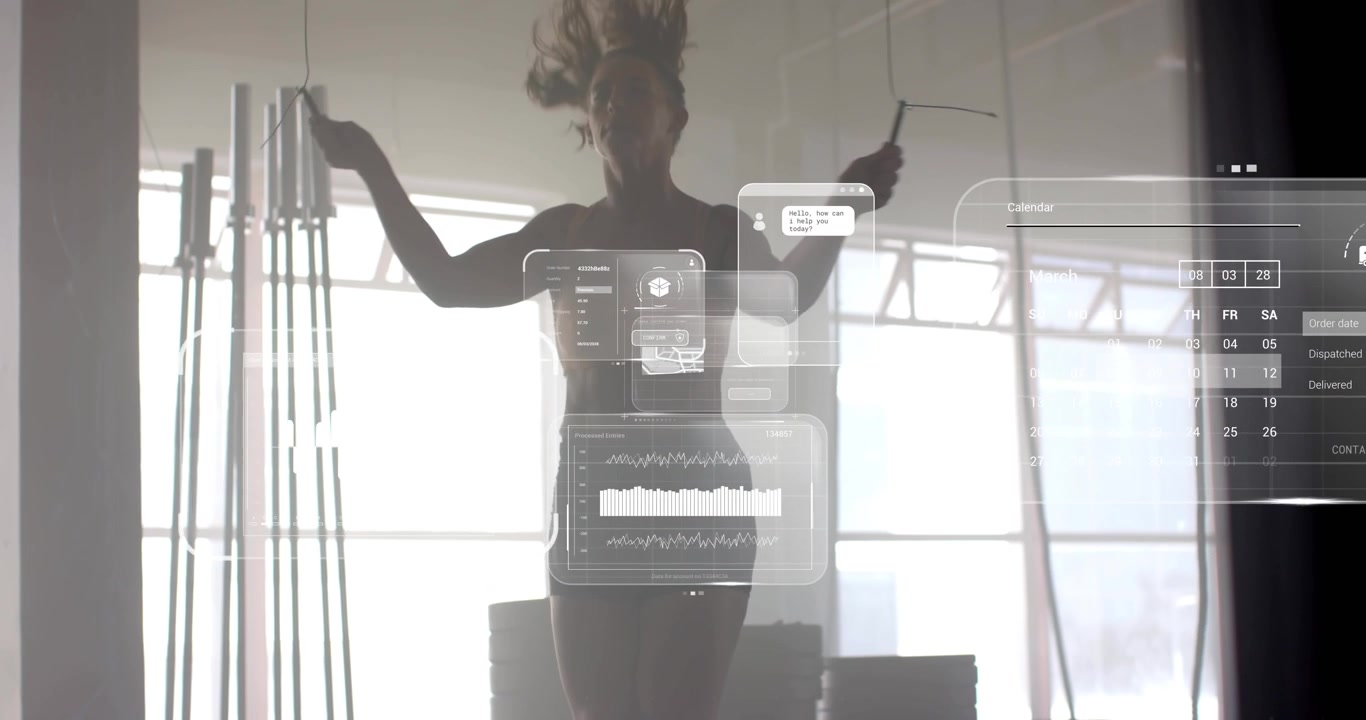 Woman jumping rope in fitness studio activating holographic charts and chat bubble tracking stats