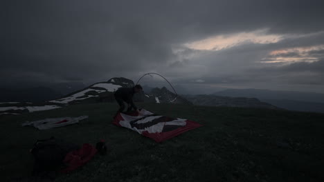 setting up tent in the mountains at dusk