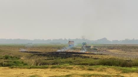 Brennendes-Ackerland-In-Asien,-Damit-Der-Boden-Wiederverwendet-Werden-Kann,-Bulldozer-Bereitet-Den-Boden-Im-Hintergrund-Vor