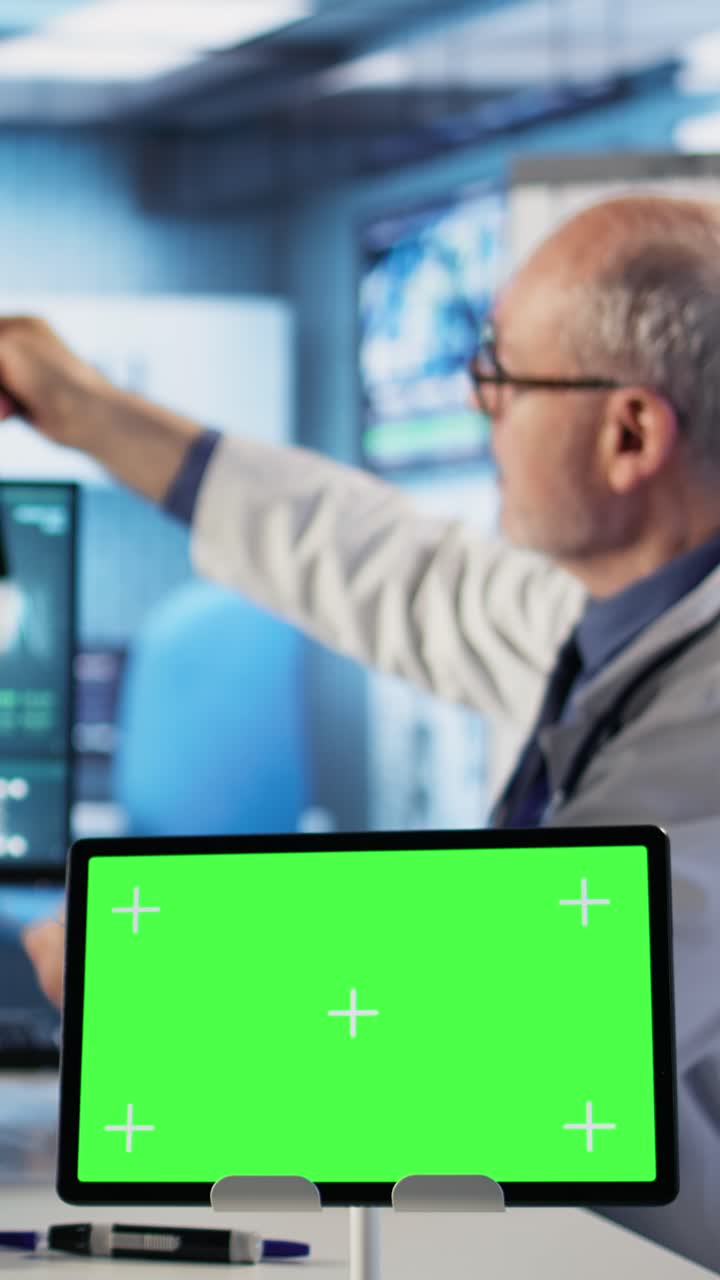 Doctor reviewing medical images on a green screen tablet