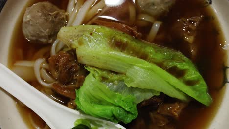 a bowl of beef noodle soup with vegetables