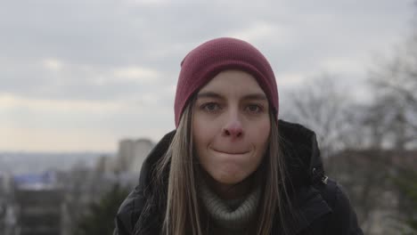 caucasian young woman smiling at camera and suddenly making angry face