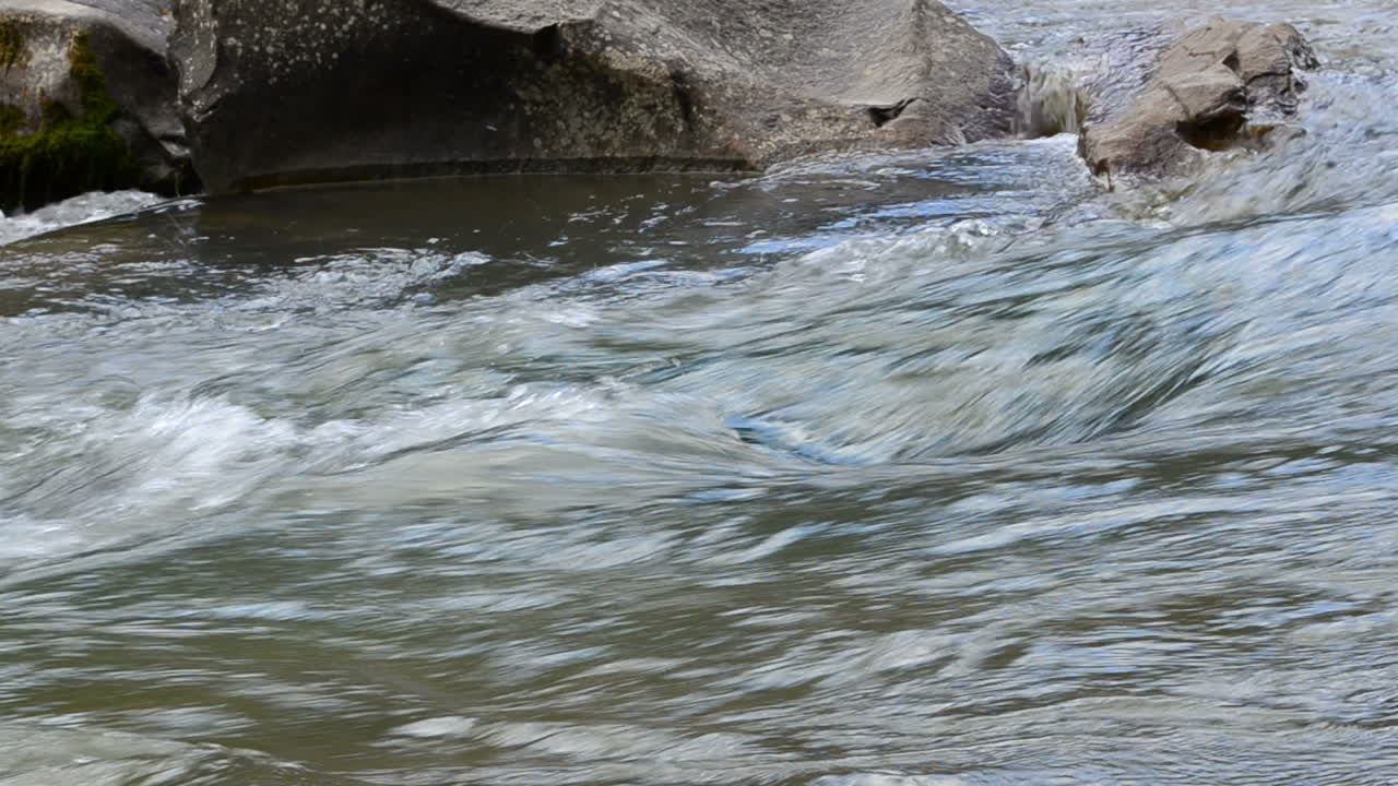 Imagem de um rio de montanha a correr. Pedras e água.