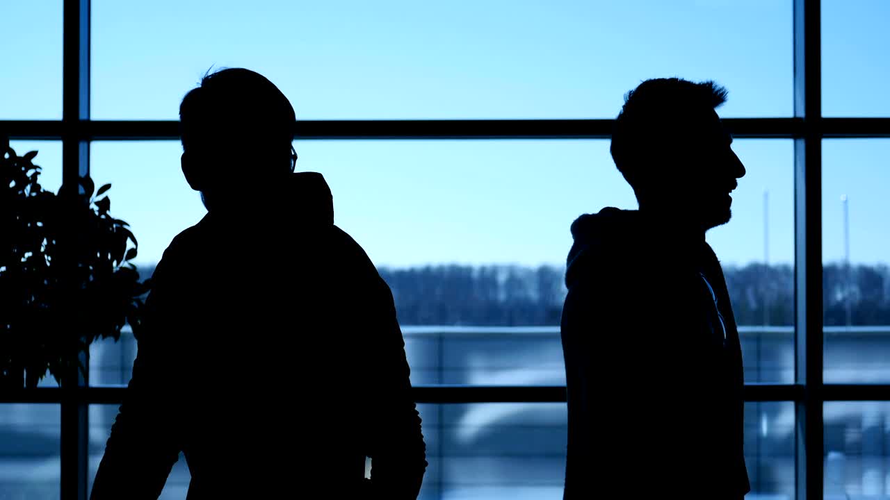 Silueta de dos hombres dándose la mano y reuniéndose en el vestíbulo de una conferencia educativa