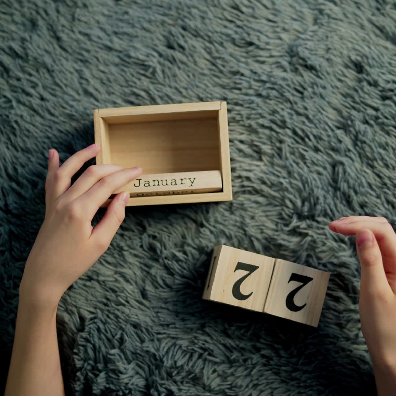 Hands of a boy flip over wood wooden cubes. Wooden cube calendar