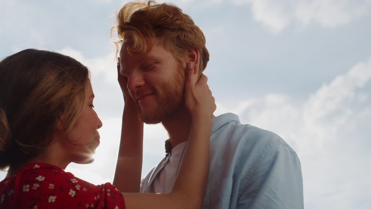 Joyful couple embrace together by sunset sky portrait. Two lovers hug outdoors.