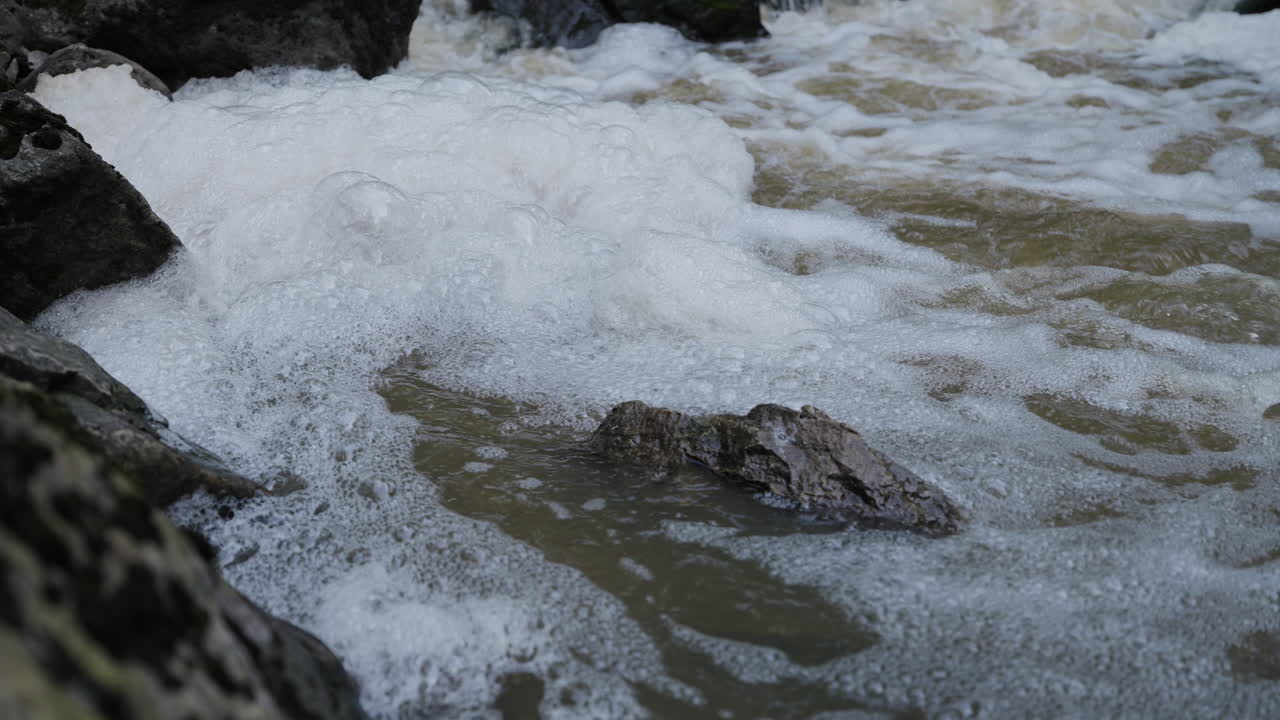 White foamy water rushing over rocks at 15 Mile Creek in Niagara