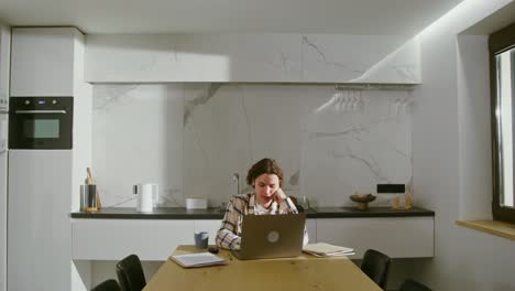 person working on laptop in a modern kitchen at home