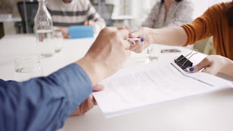 female executive handing over partnership agreement businessman signing contract in creative modern office with natural light