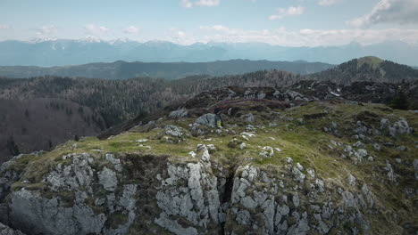 tiro de drone de um topo da montanha ratitovec com montanhas circundantes visíveis e algumas nuvens no céu