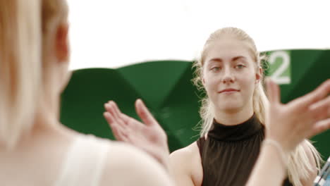 Caucasian-female-tennis-players-handshaking-at-the-tennis-court-after-match-or-practice.-4K-UHD-RAW-graded-footage