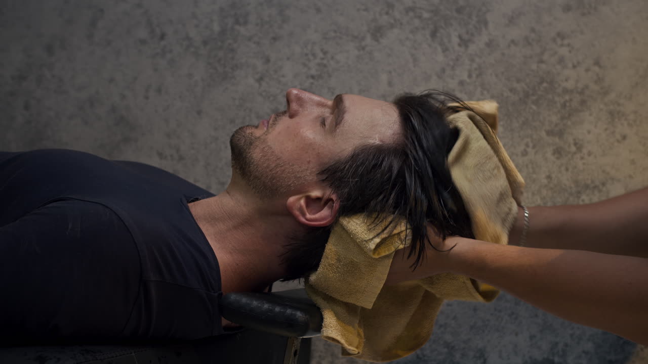 Man getting his hair washed and dried at a salon